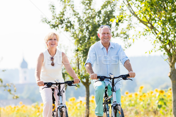 Senior couple, woman and man, riding their bikes Stock photo © Kzenon