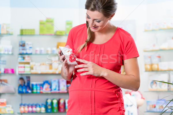 Pregnant woman in pharmacy or drug store Stock photo © Kzenon