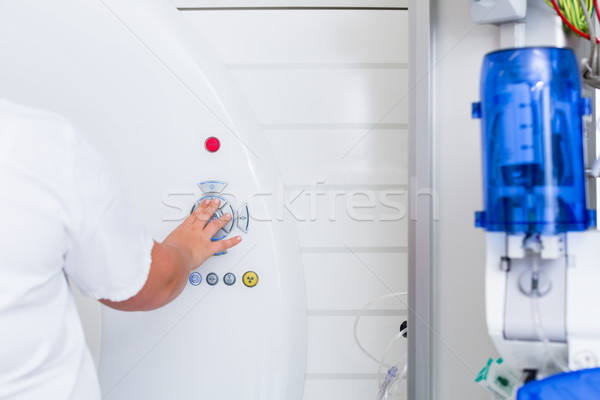 Stock photo: Nurse pressing button on CT machine in hospital