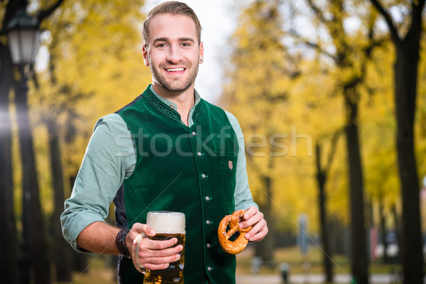Man in traditional bavarian Tracht drinking beer out of huge mug Stock photo © Kzenon