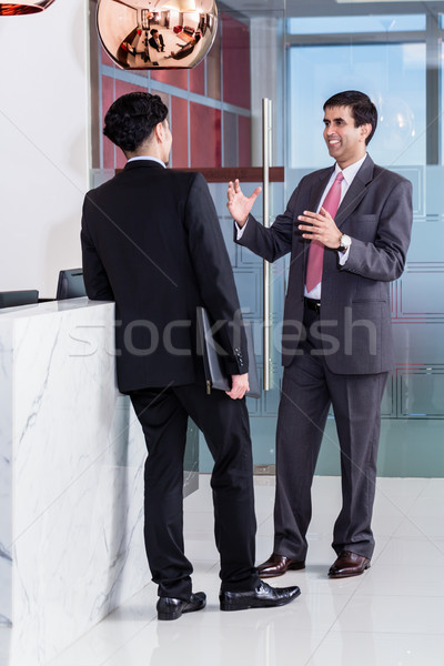 Manager and affiliate leaning at front desk of office  Stock photo © Kzenon