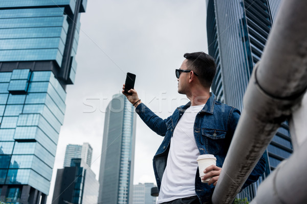 Fiatalember elvesz képek modern üzleti negyed alulról fotózva Stock fotó © Kzenon