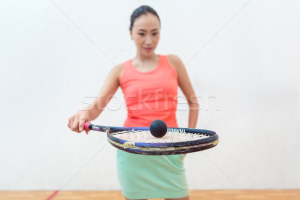 Close-up of a rubber hollow ball on the new squash racket of a fit woman Stock photo © Kzenon