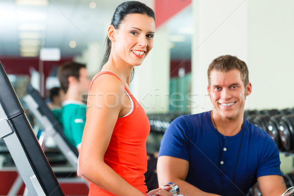 Stock photo: woman and Personal Trainer in gym, with dumbbells