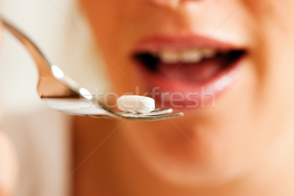 Woman eating nutritional supplements Stock photo © Kzenon
