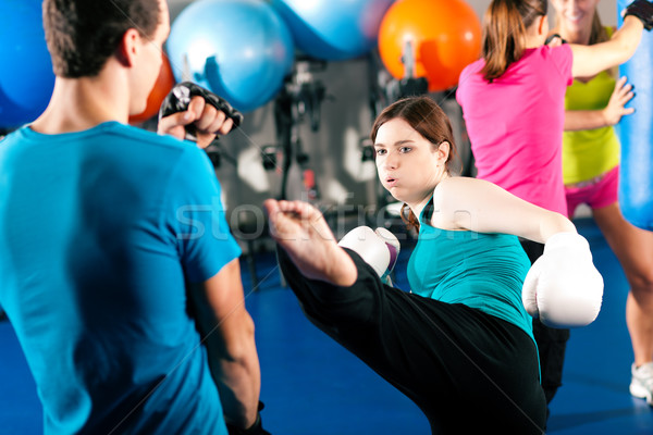 Female kick boxer with trainer in sparring Stock photo © Kzenon