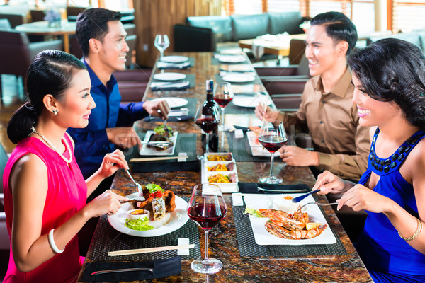 Asian Friends eating  in restaurant Stock photo © Kzenon