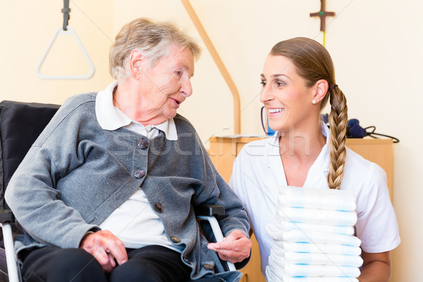 Nurse bringing supplies to woman in retirement home Stock photo © Kzenon