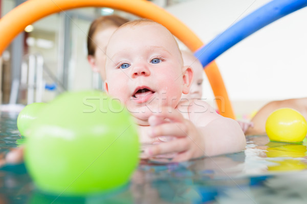 Baby in paddle pond reaching for toy ball in water Stock photo © Kzenon