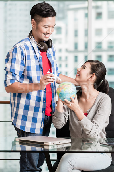 Asian couple with globe and model airplane in urban apartment Stock photo © Kzenon
