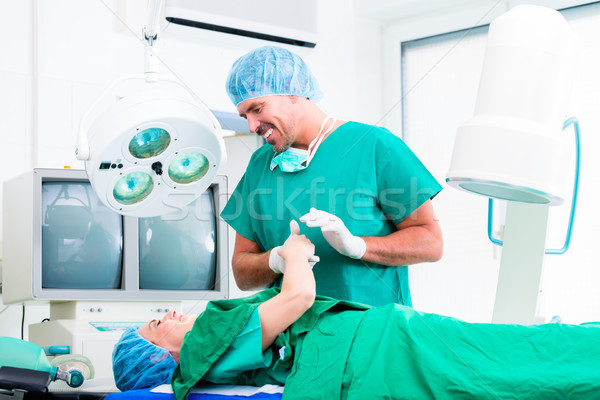 Surgeon in operating room holding hand of patient Stock photo © Kzenon
