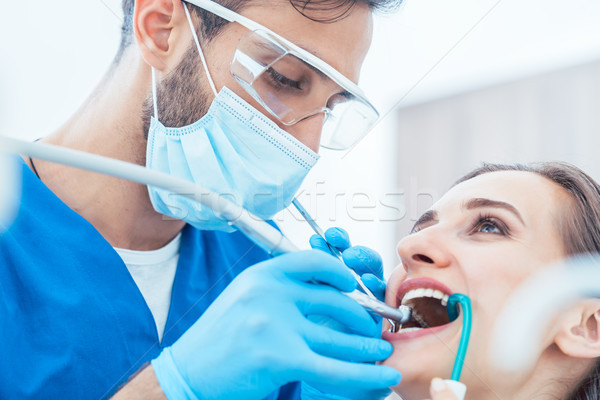 Young woman during painless oral treatment in a modern dental office Stock photo © Kzenon