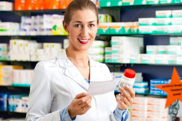 Female pharmacist in pharmacy with medicament Stock photo © Kzenon