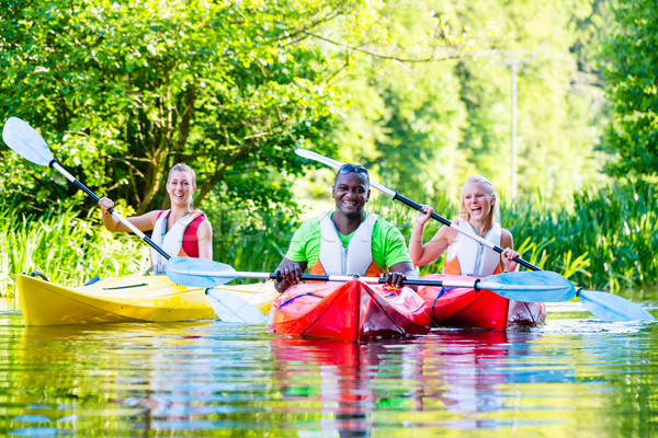 Friends paddling with canoe on forest river Stock photo © Kzenon