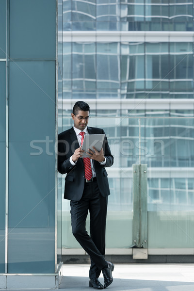 Indian businessman using a tablet PC indoors Stock photo © Kzenon