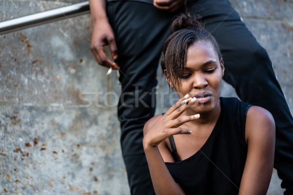Jonge afro-amerikaanse vrouw man roken buitenshuis Stockfoto © Kzenon