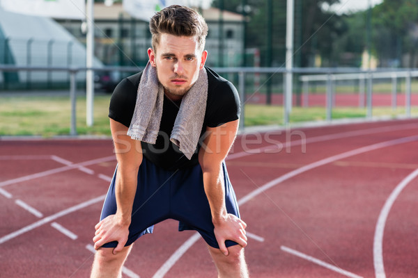 Athlete stretching on racing track before running Stock photo © Kzenon