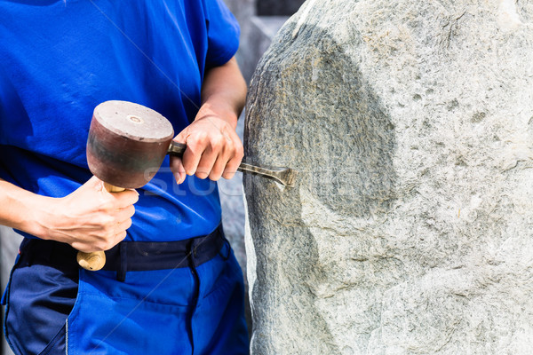 Stonemason working on boulder with sledgehammer and iron Stock photo © Kzenon