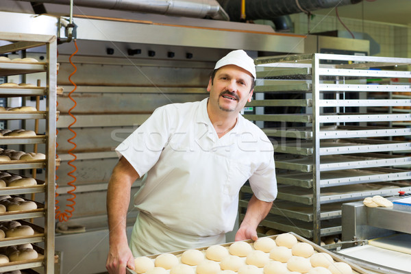 Male baker baking bread rolls Stock photo © Kzenon