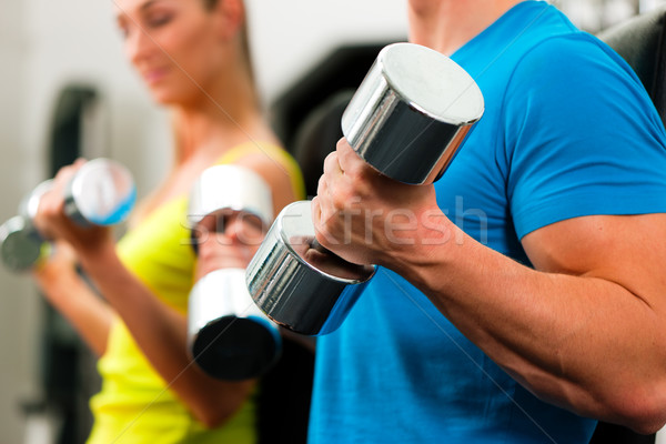 couple in gym exercising with dumbbells  Stock photo © Kzenon