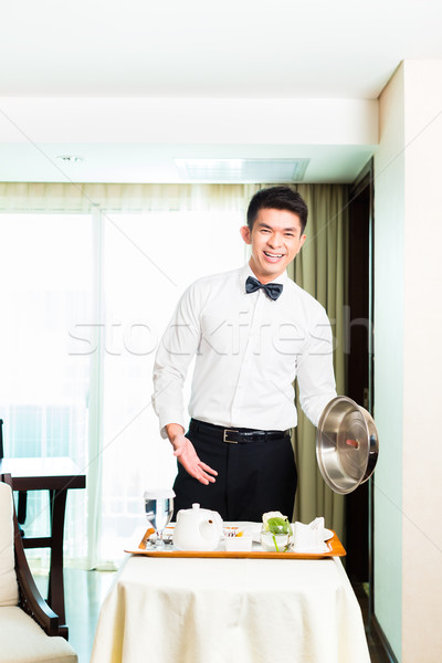 Asian Chinese room waiter serving guests food in hotel Stock photo © Kzenon