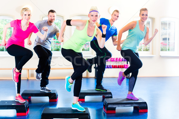 Súlyzós edzés tornaterem nő fitnessz férfiak csoport Stock fotó © Kzenon
