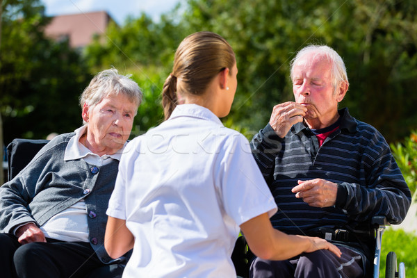 Seniors eating candy in garden of nursing home Stock photo © Kzenon