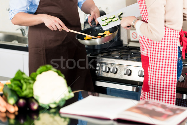 Asian couple cooking vegetables in frying pan Stock photo © Kzenon