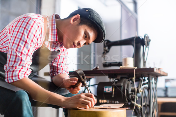Asian shoe or belt maker in his leather workshop Stock photo © Kzenon