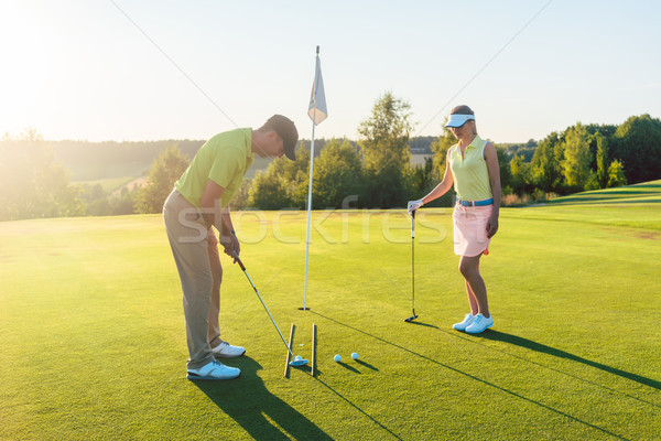 Man ready to hit the golf ball while exercising with his game pa Stock photo © Kzenon