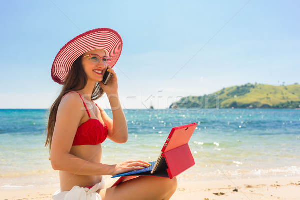 Fashionable young woman talking on mobile phone at the beach Stock photo © Kzenon
