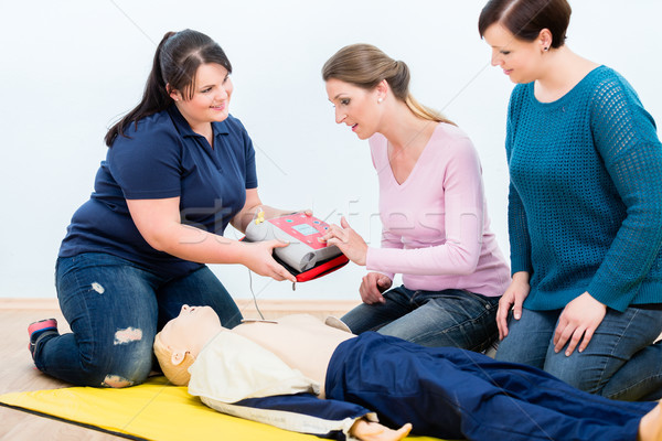 First aid trainees learning to use defibrillator for reanimation Stock photo © Kzenon