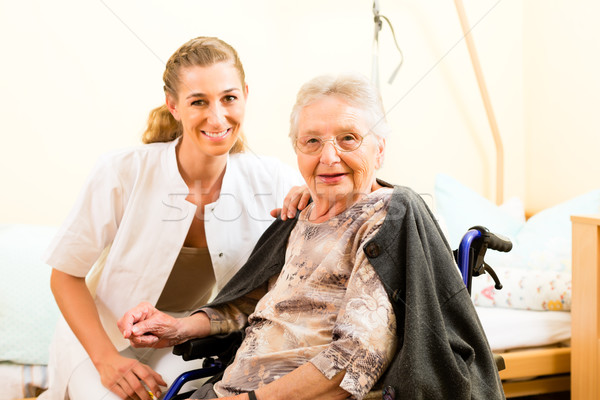 Young nurse and female senior in nursing home Stock photo © Kzenon