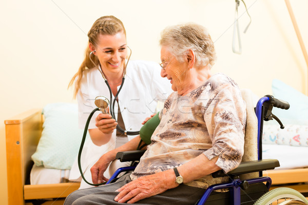 Jóvenes enfermera femenino altos asilo de ancianos presión arterial Foto stock © Kzenon