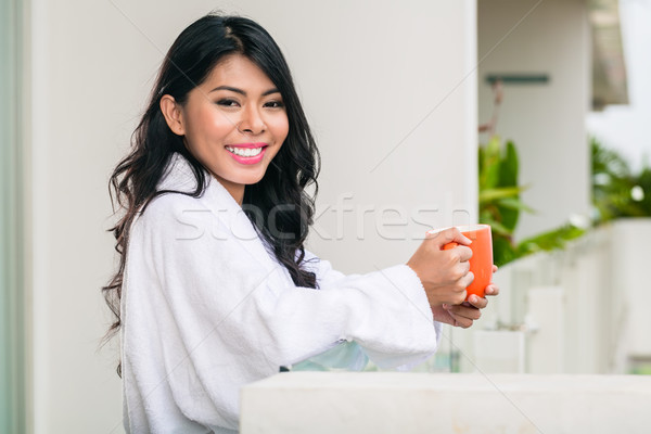 Asian woman drinking coffee on terrace Stock photo © Kzenon