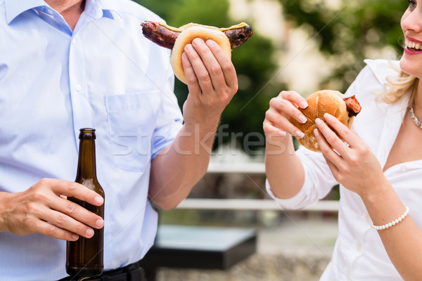 Colleagues having sausages and beer after work Stock photo © Kzenon