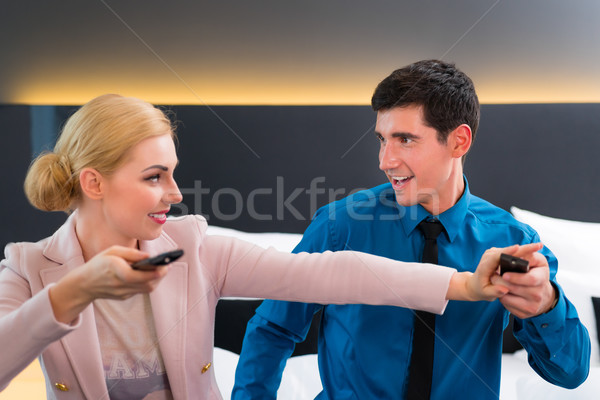 Couple switching TV with remote control in hotel room Stock photo © Kzenon