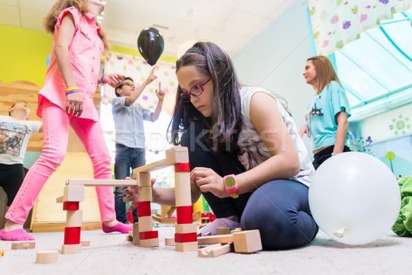 Cute girl building a structure in balance during playtime at the kindergarten Stock photo © Kzenon