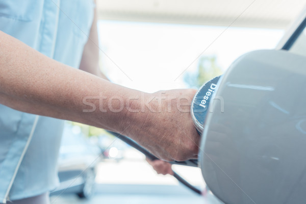 Close-up of the hand of a senior woman filling up the gas tank of her car Stock photo © Kzenon