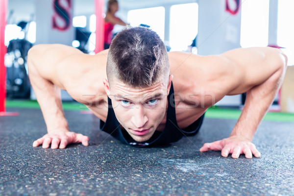 Man doing push-up in sport fitness gym Stock photo © Kzenon