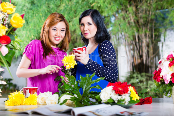 Two Asian girlfriends with flowrers Stock photo © Kzenon