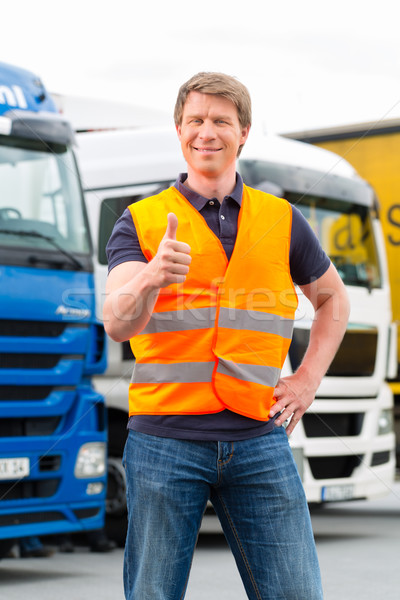 Stock photo: Forwarder or driver in front of trucks in depot
