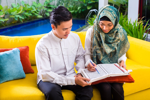 Asian Muslim couple reading together Koran or Quran  Stock photo © Kzenon