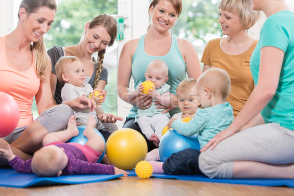 Young women in mother and child group playing with their baby ki Stock photo © Kzenon