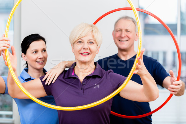 Senior couple in physiotherapy doing exercise with hula hoop Stock photo © Kzenon