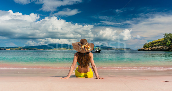 Young woman sitting on the sand at Pink Beach in Komodo Island,  Stock photo © Kzenon