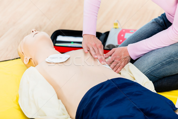 Stock photo: First aider trainee learning revival with defibrillator