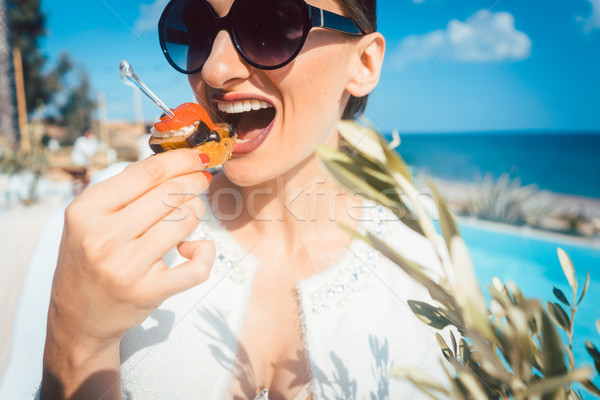 Nő élvezi étel medence vendéglátás tengerparti ház Stock fotó © Kzenon