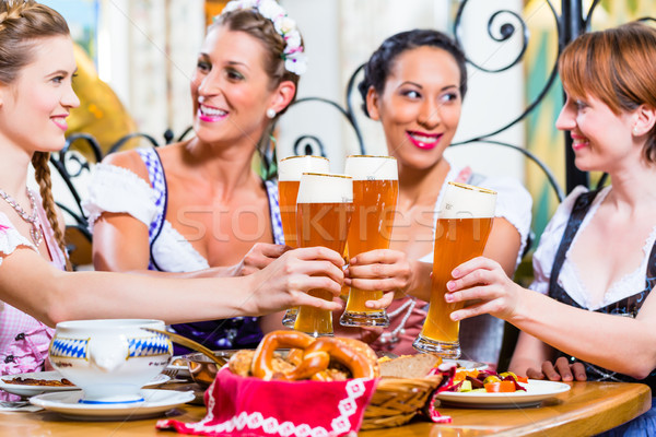 Girls toasting with wheat beer in Bavarian pub Stock photo © Kzenon