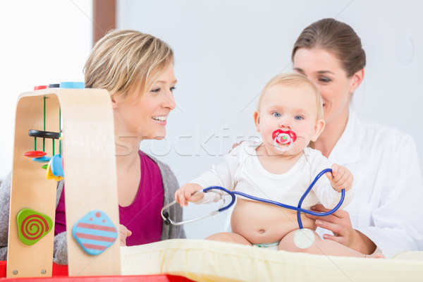 Cute and healthy baby girl playing with the stethoscope during examination Stock photo © Kzenon